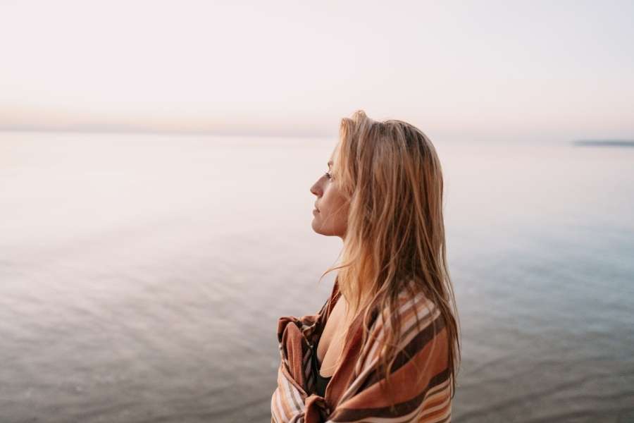 A woman looking at the sea during mindfulness practices.