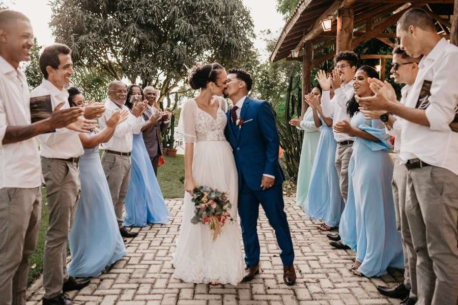 Newlyweds kissing as guests applaud and celebrate a stress-free wedding day